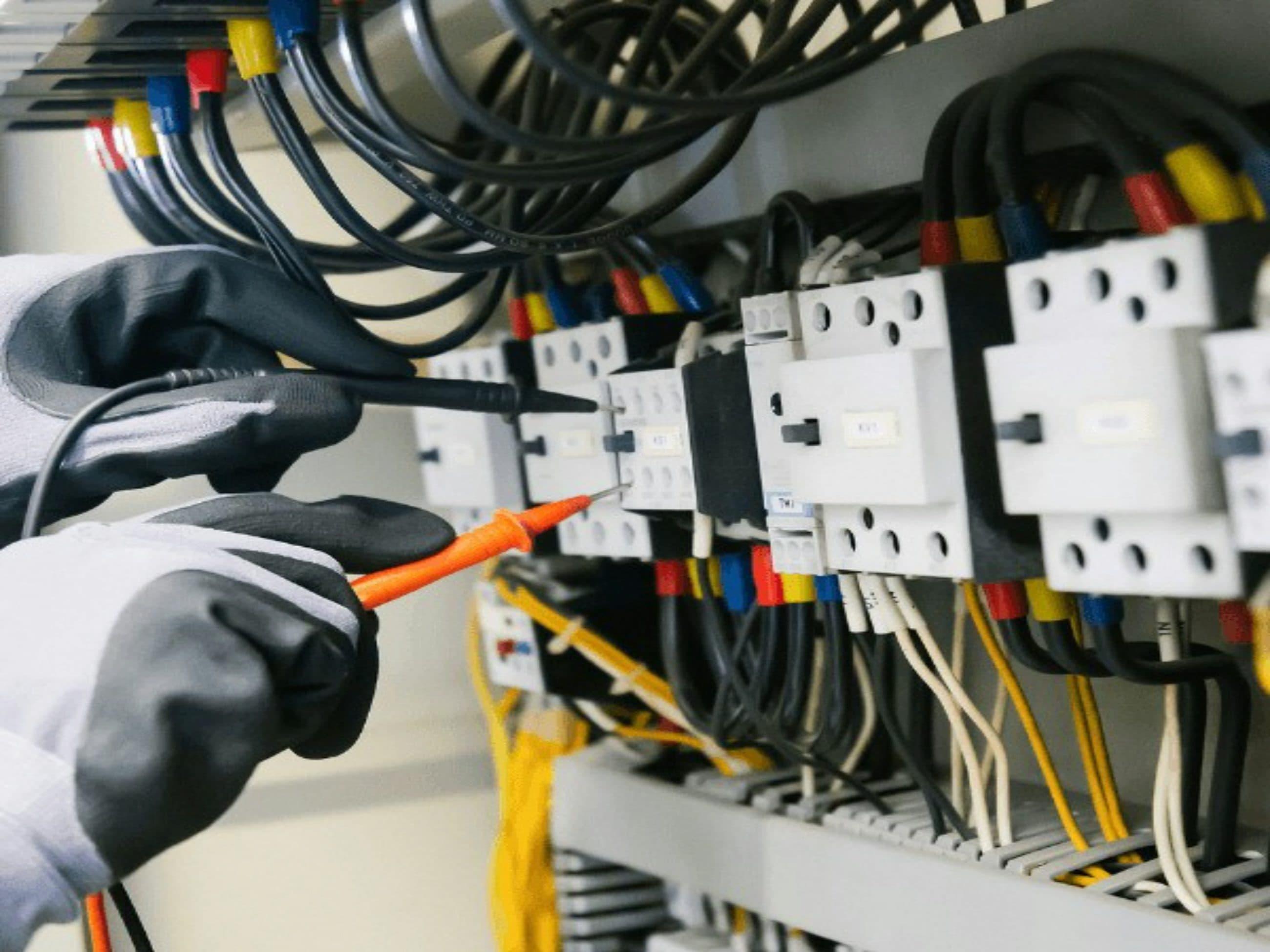 Terminal block being wired and torque-checked inside a control panel