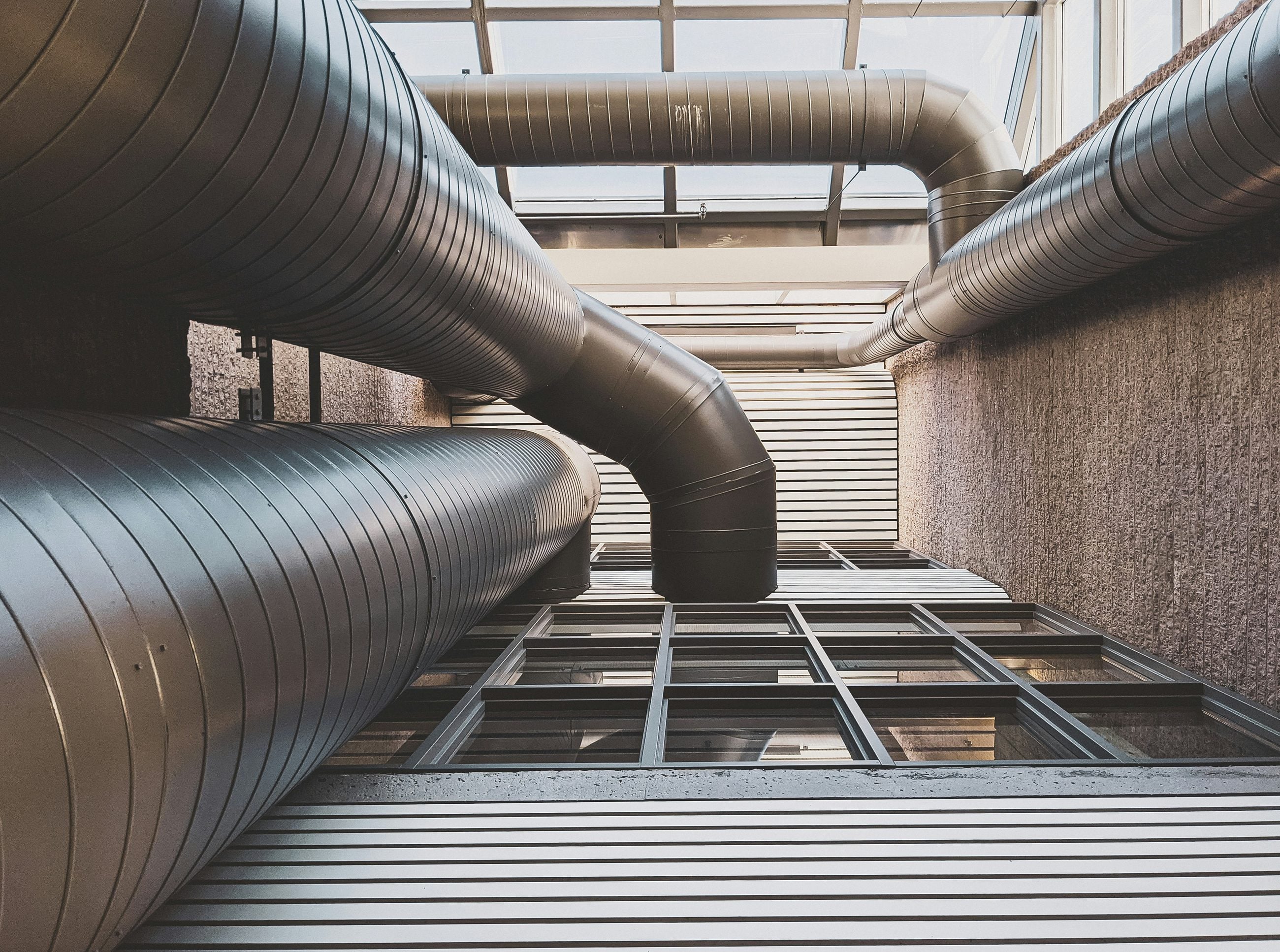 Spiral ductwork and ventilation runs installed across a building ceiling
