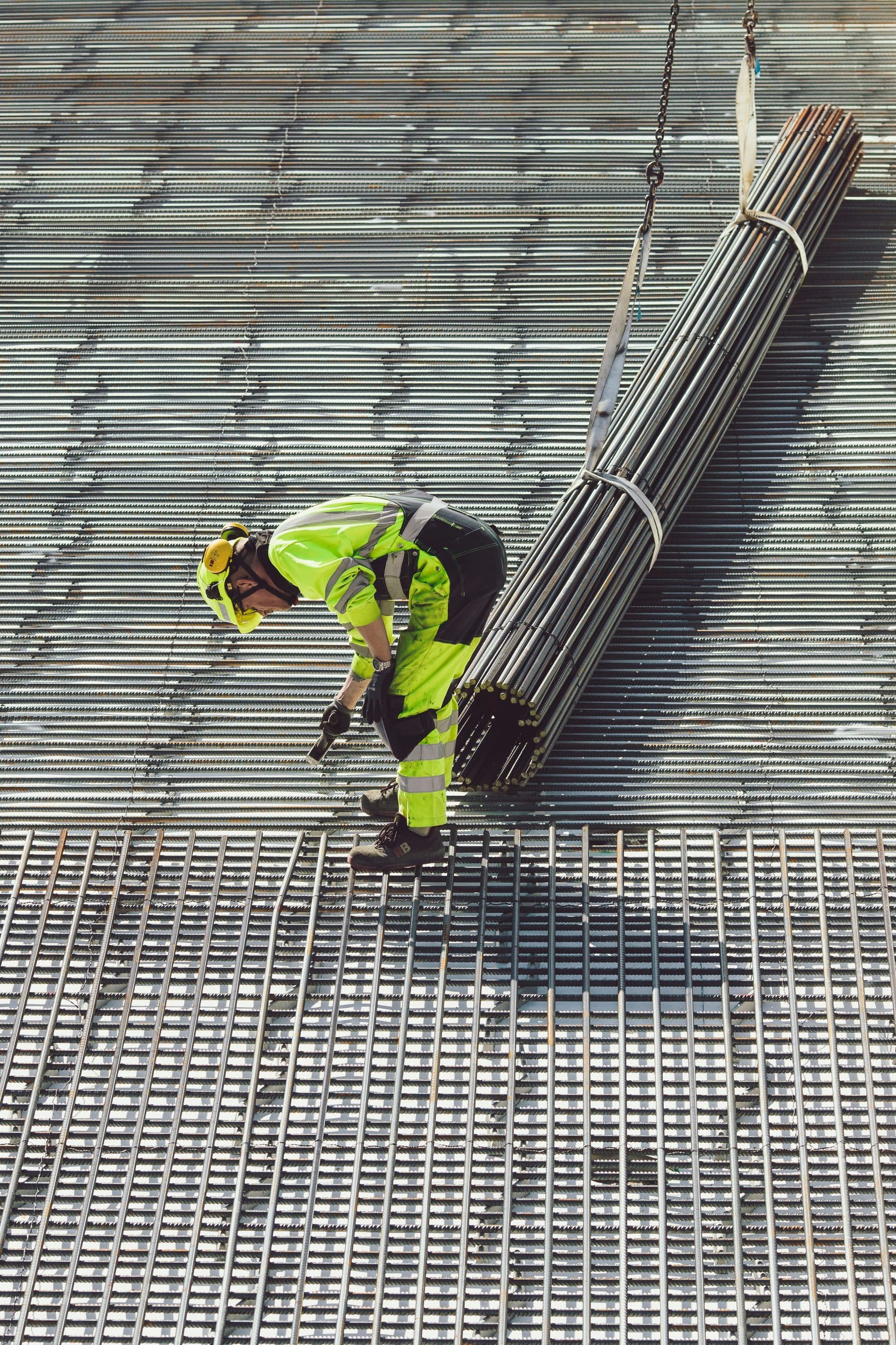 Worker positioning reinforcement mesh ahead of a concrete pour