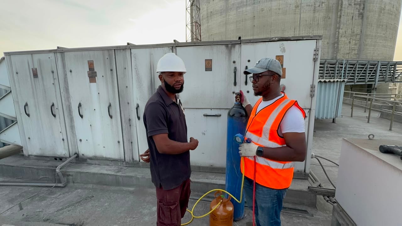 Helmont technicians reviewing work at an electrical cabinet on site