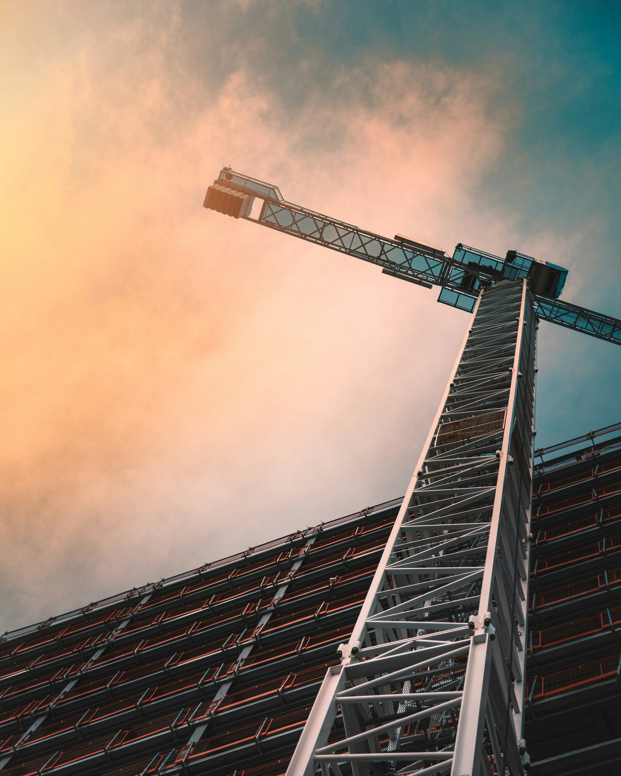 Tower crane rising above a project site at dusk