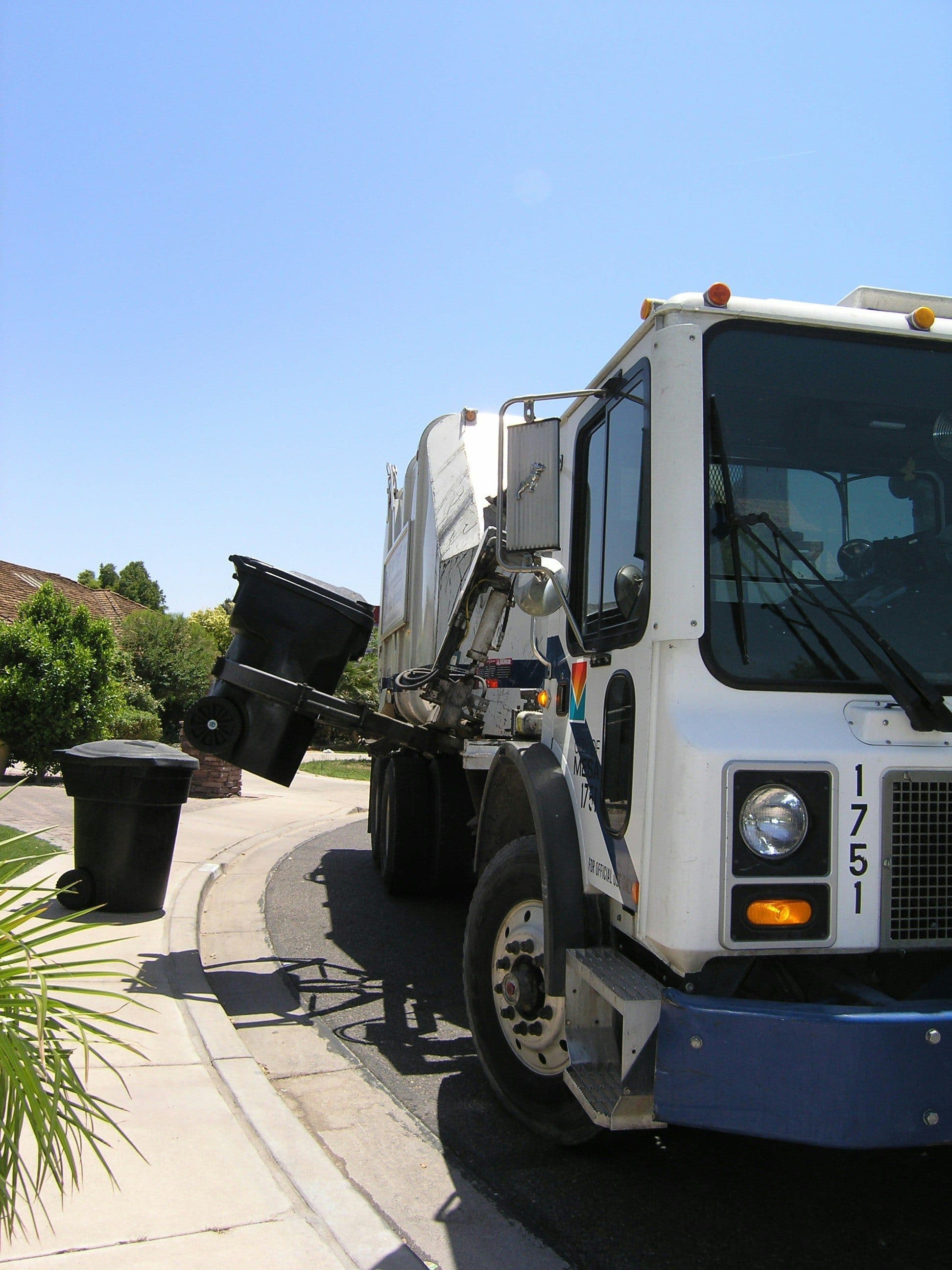 Refuse collection truck servicing bins on a scheduled route